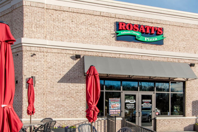 Picture of a Rosati's franchise exterior with red umbrellas and brick
